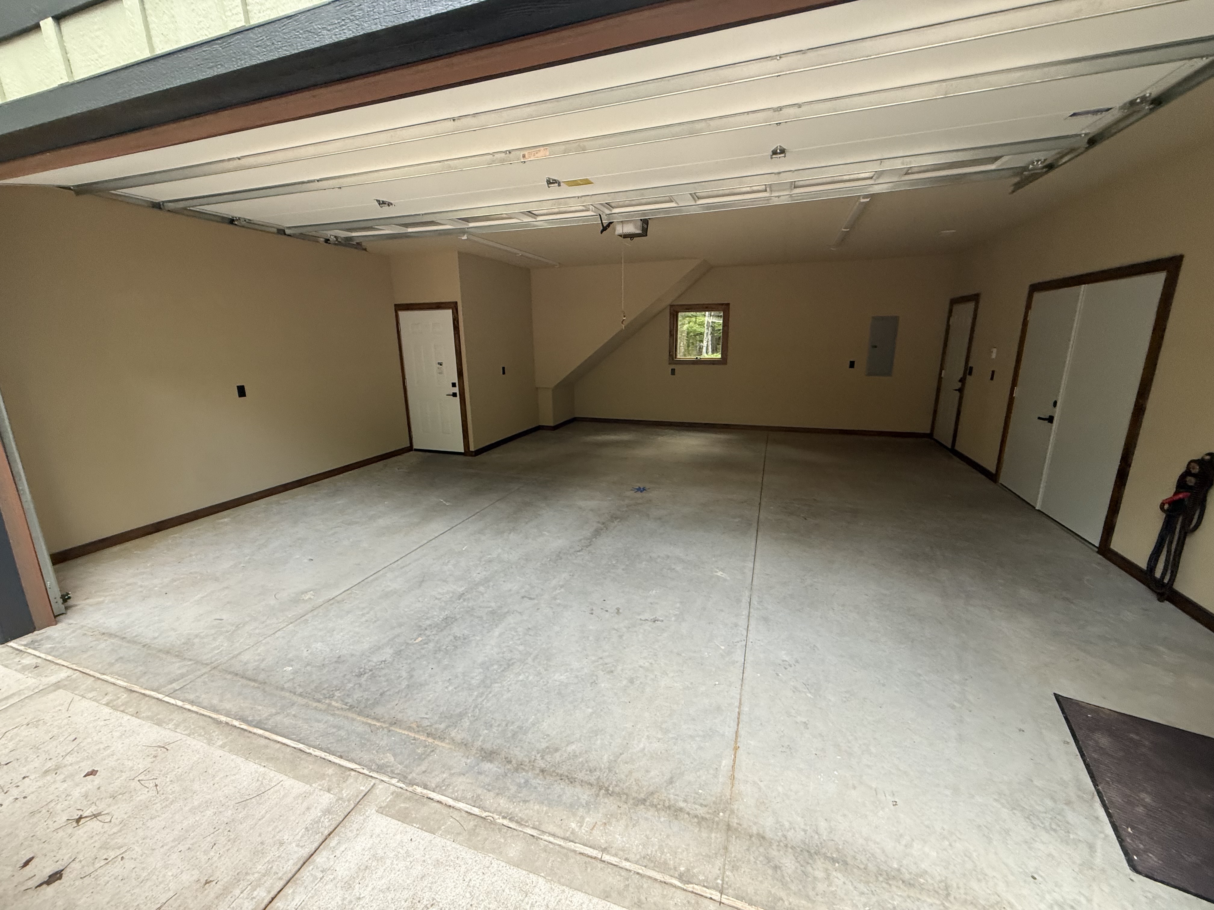 Cracked, stained bare concrete garage floor before coating